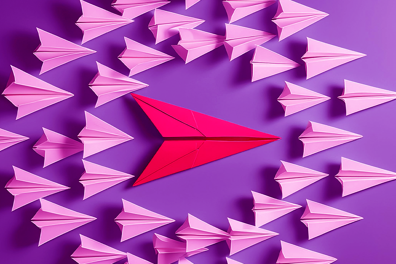Aviones de papel color purpura rodeando a avión de papel rojo 